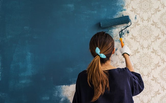 Women-painter-painting-the-walls-over-wallpaper-min как правильно красить стены